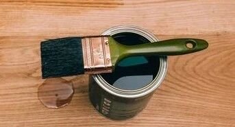 A brush on top of a paint bucket