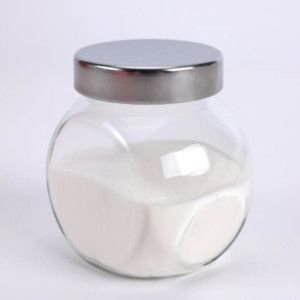 Glass jar with a metal lid filled with white granulated sugar on a white background.