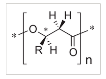 Structural formula of a polymer repeating unit with a cyclic ring, ester group, and stereochemistry, bracketed as [ ... ]n to indicate polymerization.