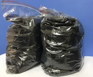 Carbon Nanotube Two large black trash bags inside clear outer bags, standing upright against a blue background.
