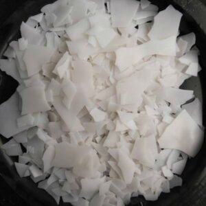 Polyethylene White plastic shreds piled in a dark container.